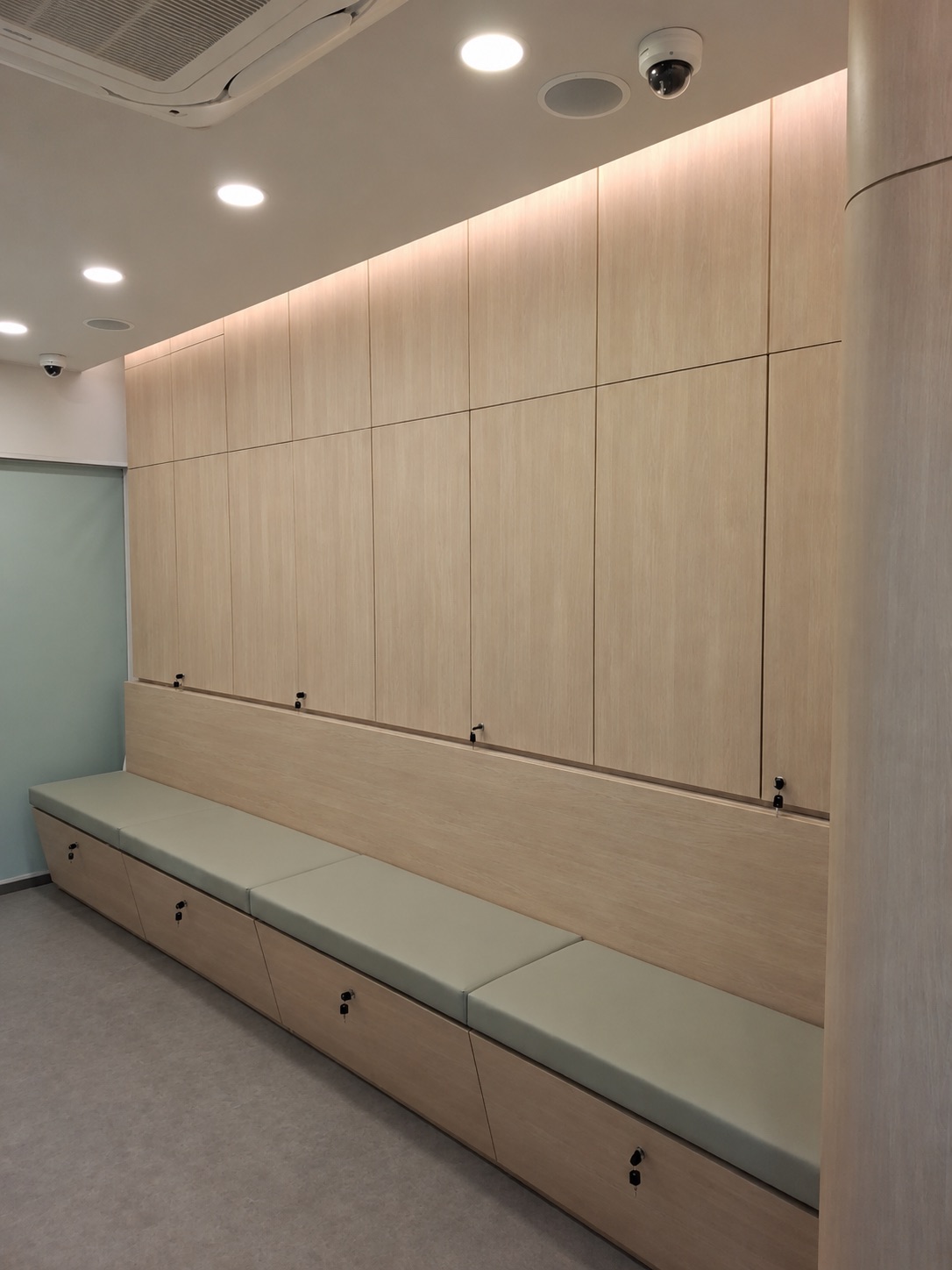 Clinic waiting area with upholstered bench seating and lockable storage