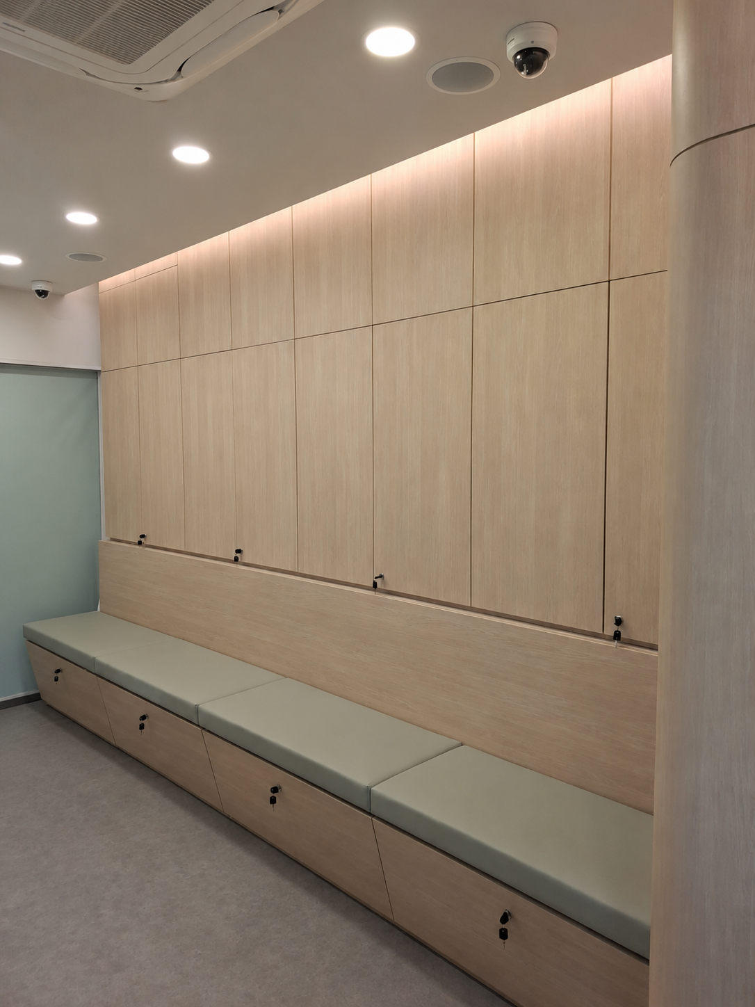Clinic waiting area with upholstered bench seating and lockable storage