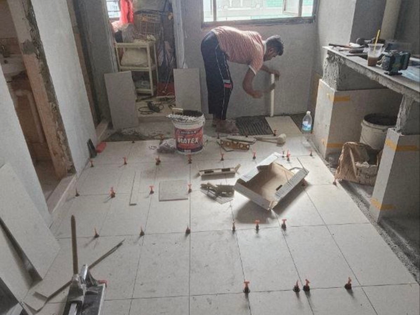 Floor tiling in progress in an HDB flat